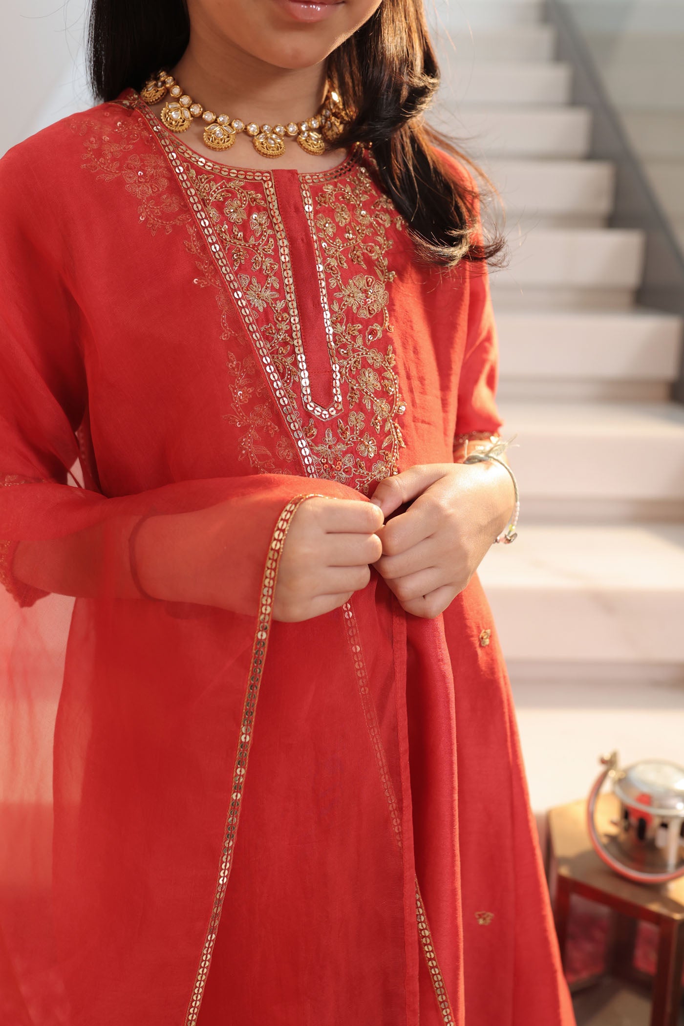 Vibrant red suit adorned with delicate golden zari embroidery and subtle detailing for an elegant festive charm