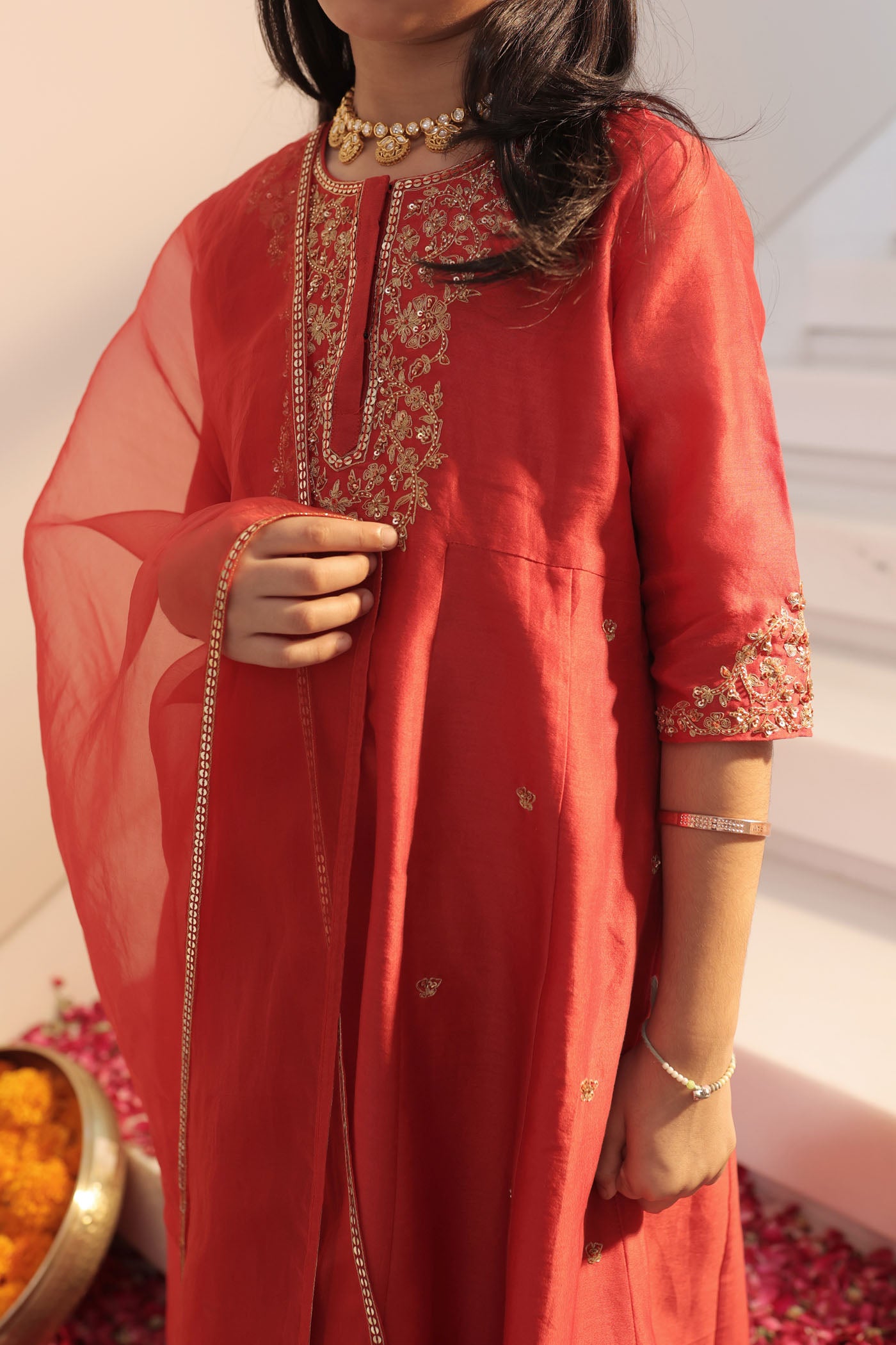 Vibrant red suit adorned with delicate golden zari embroidery and subtle detailing for an elegant festive charm