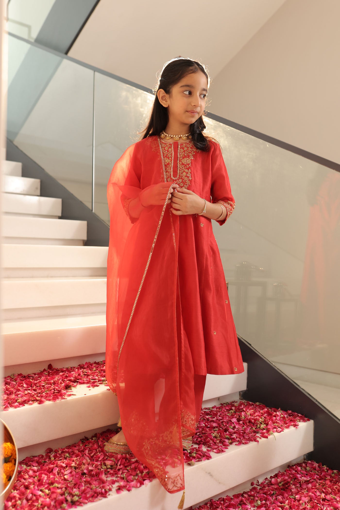 Vibrant red suit adorned with delicate golden zari embroidery and subtle detailing for an elegant festive charm
