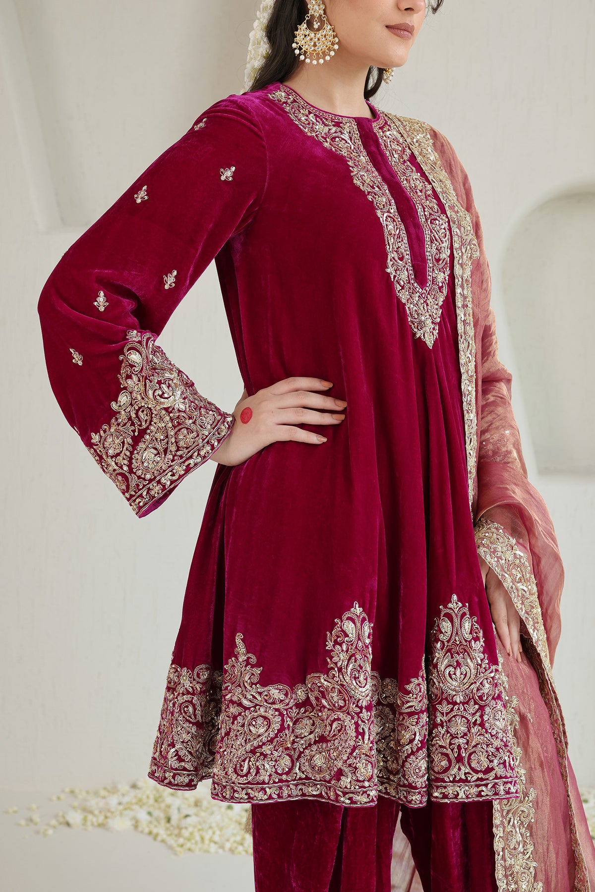 Bright pink velvet paired with a soft blush dupatta and intricate antique-gold embroidery