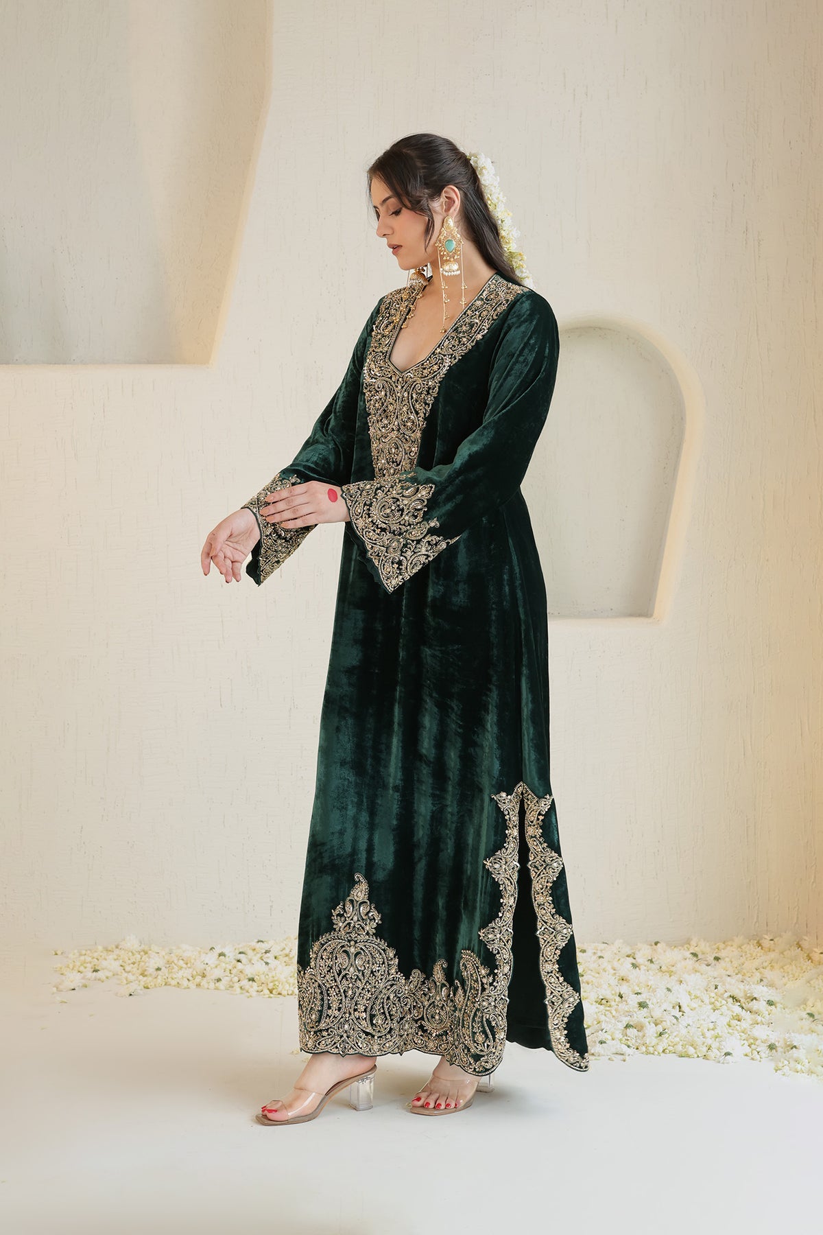 A rich emerald velvet ensemble adorned with intricate antique-gold embroidery.