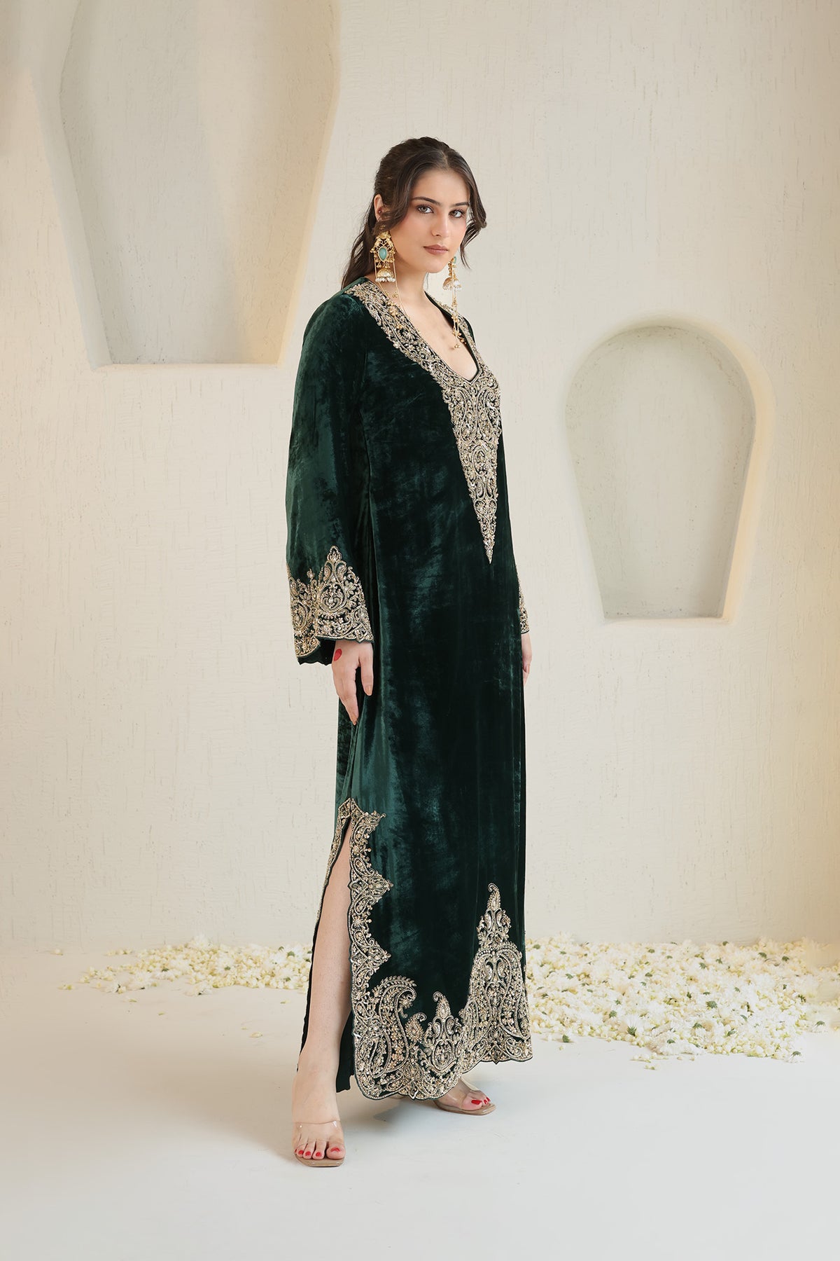 A rich emerald velvet ensemble adorned with intricate antique-gold embroidery.