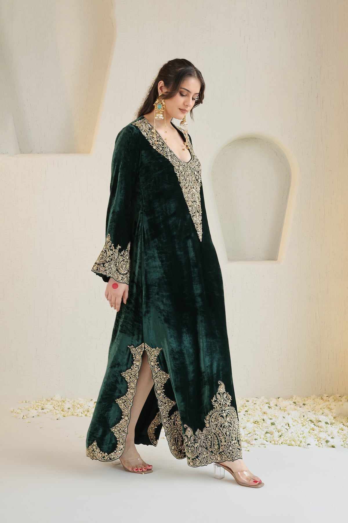 A rich emerald velvet ensemble adorned with intricate antique-gold embroidery.