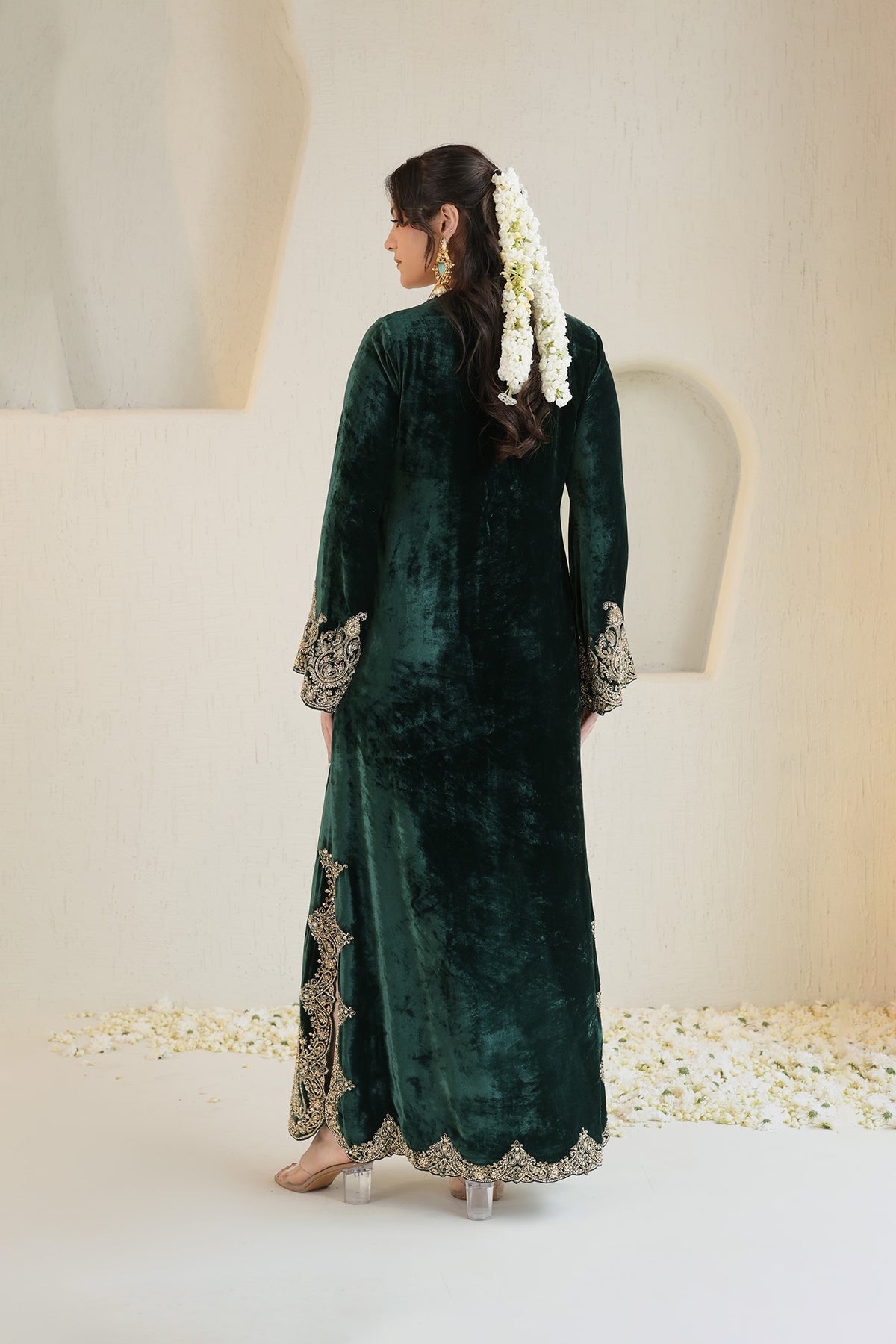 A rich emerald velvet ensemble adorned with intricate antique-gold embroidery.