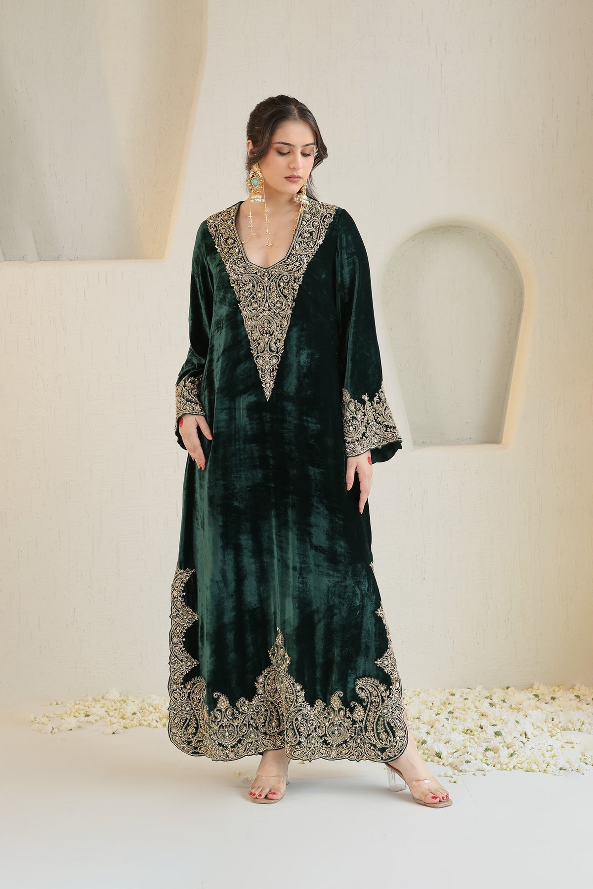 A rich emerald velvet ensemble adorned with intricate antique-gold embroidery.